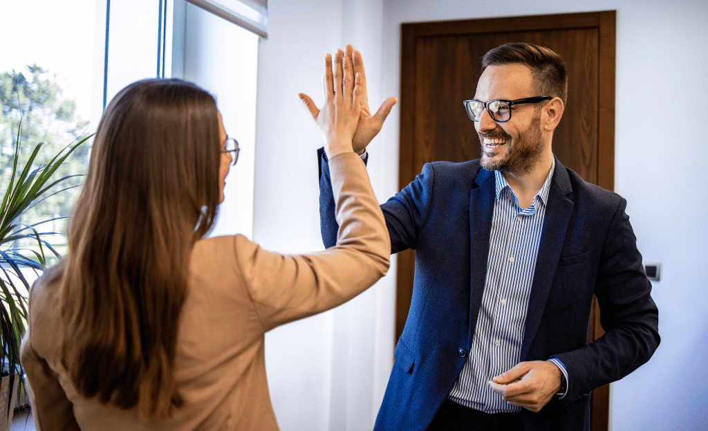two coworkers high-fiving and celebrating success