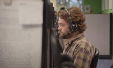 inside sales agent with headset on at desk